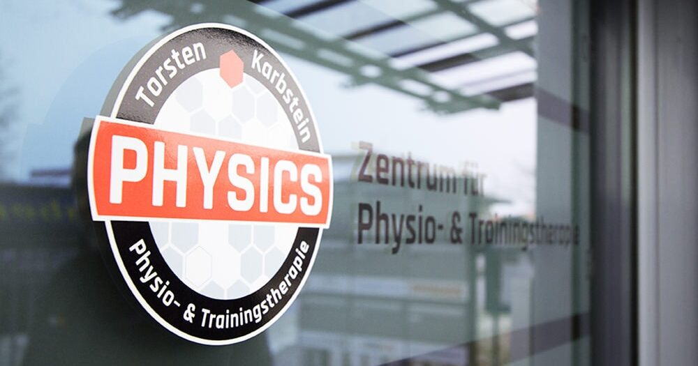 Nahaufnahme einer Glasfläche mit mattierter Folierung im Hintergrund und dem Logo von PHYSICS, dem Physio- und Trainingstherapie-Zentrum. Im Glas spiegelt sich die Umgebung.